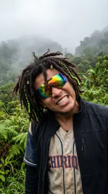 Man with dreadlocks in misty forest