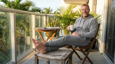 Man Relaxing on Balcony with Coffee