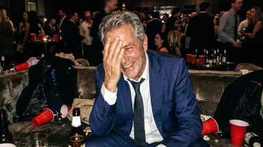 man in blue suit at crowded party