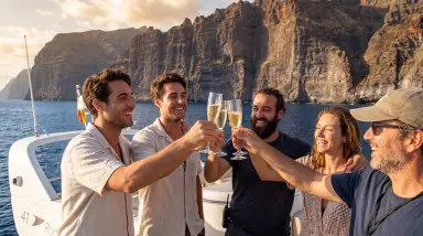 friends toasting champagne on boat with cliffs