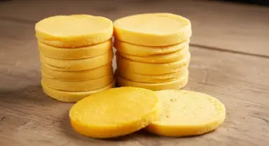 stacked yellow cookies on wooden surface
